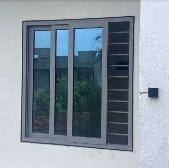 Grey sliding window with a fixed grill panel on one side
