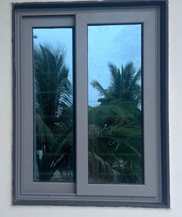 Grey two-track sliding window reflecting palm trees