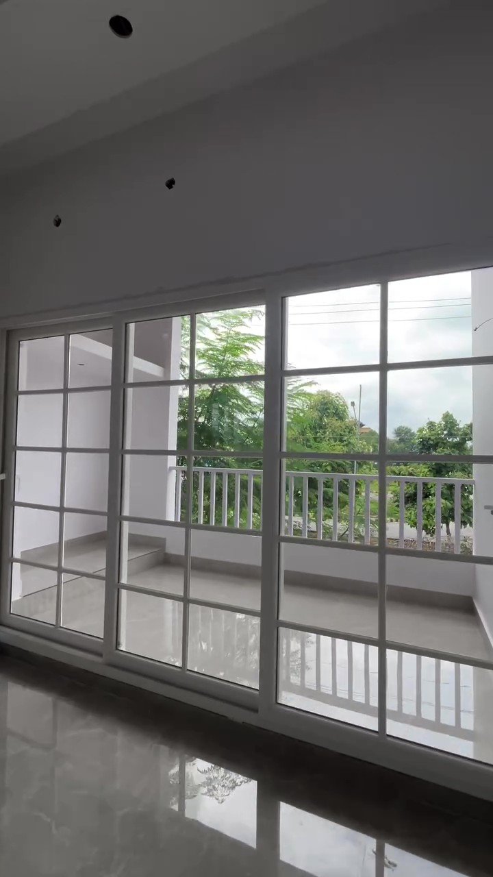 White UPVC sliding doors with grid bars opening onto a balcony with railings